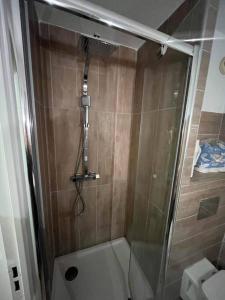een badkamer met een douche en een glazen deur bij Studio avec coin nuit vue mer - la ciotat in La Ciotat