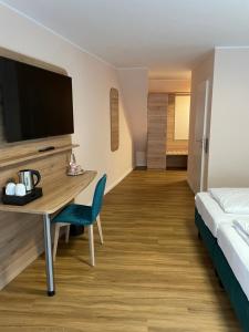 a hotel room with a bed and a desk with a tv at Art Hotel Eifel in Heimbach +41 photos