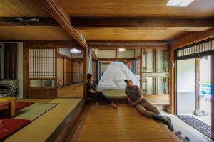 two people sitting in a room with a tent at River, Mountain Retreat at 四万十Accommodation in Mihara