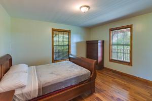 1 dormitorio con 1 cama y 2 ventanas en Idyllic Beattyville Cabin Rental with Stunning Views en Beattyville