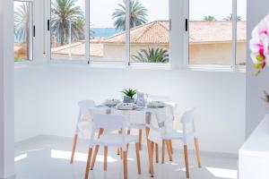 a white dining room with a white table and chairs at La Mata Londres 2 in La Mata
