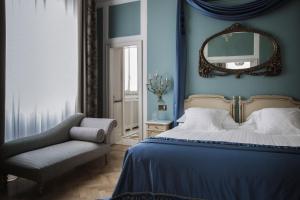 1 dormitorio con cama, silla y espejo en Grand Hotel et de Milan - The Leading Hotels of the World, en Milán