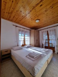 1 dormitorio con 1 cama grande y techo de madera en OASIS BEACH HOUSE en Vergia