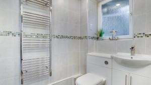 Baño blanco con aseo y lavamanos en Limeslade Court, en Mumbles