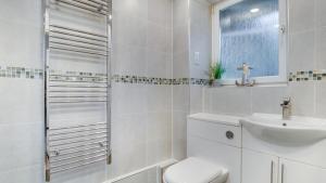 a white bathroom with a toilet and a sink at Limeslade Court in The Mumbles