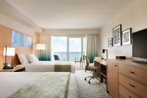 a hotel room with two beds and a television at Surfbreak Virginia Beach Oceanfront, Ascend Hotel Collection in Virginia Beach