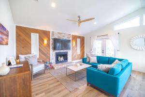 a living room with a blue couch and a fireplace at Bright New Beach House with In- Law Suite -- 2 blocks to beach! in Saint Augustine