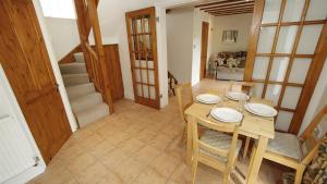 a dining room with a table and chairs and a staircase at Llethryd Farm Cottage Two in Llanmorlais