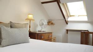a bedroom with a white bed with a lamp and windows at Llethryd Farm Cottage Two in Llanmorlais