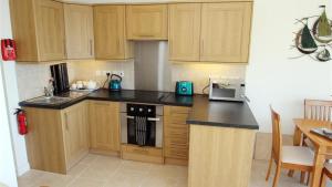 a kitchen with wooden cabinets and a stove top oven at Redcliffe Apartments I in Bishopston +3 photos