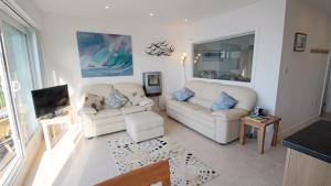 a living room with two white couches and a tv at Redcliffe Apartments I in Bishopston