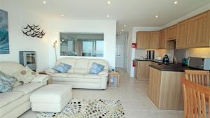 a living room with a white couch and a kitchen at Redcliffe Apartments I in Bishopston
