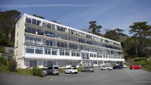 a large white building with cars parked in a parking lot at Redcliffe Apartments I in Bishopston