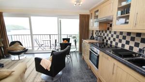 een keuken met stoelen en uitzicht op een balkon bij Redcliffe Apartments C in Bishopston