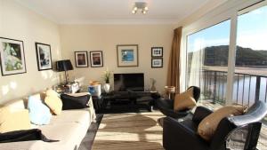 een woonkamer met een bank en stoelen en een televisie bij Redcliffe Apartments C in Bishopston
