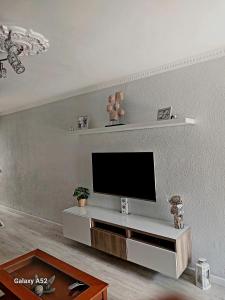 sala de estar con TV de pantalla plana en la pared en Casa lunera, en Mijas Costa