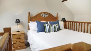 a bedroom with a bed with a wooden headboard and a night stand at Llethryd Farm Cottage One in Llanmorlais