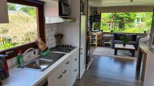 a kitchen with a sink and a stove top oven at Chalet 553 op Recreatiepark De Wielen in Sint Maarten +31 photos