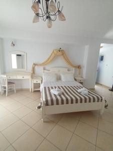 a bedroom with a bed and a chandelier at Theofanis Studios in Agia Anna Naxos
