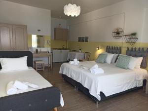 a room with two beds with towels on them at Theodora Rooms in Poros