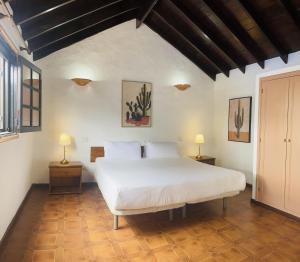 une chambre avec un grand lit blanc et deux lampes dans l'établissement Villa Estefania, à Playa Blanca 38 autres photos