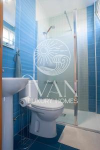 bagno blu con servizi igienici e doccia di Casa OroMar IVAN LUXURY HOMES Chalet Adosado a Oropesa del Mar