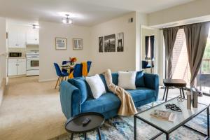 a living room with a blue couch and a table at Cozy Laurel Condo with Pool Access, about 20 Mi to DC! in Laurel