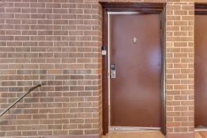 a brown door in a brick wall at Cozy Laurel Condo with Pool Access, about 20 Mi to DC! in Laurel