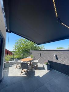 a patio with a table and chairs and a brick wall at Casa 47 in Eupen