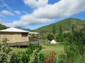 a yurt in a field with mountains in the background at le moulin in Pradelle