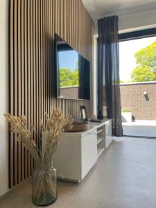 a bathroom with a mirror and a vase with flowers at Casa 47 in Eupen