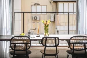 a table with chairs and a vase of flowers on a balcony at Spacious & Bright 3BR Apt Near the Beach & Port by Sea N' Rent in Tel Aviv