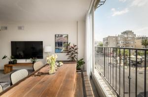 a balcony with a wooden table and a large window at Spacious & Bright 3BR Apt Near the Beach & Port by Sea N' Rent in Tel Aviv
