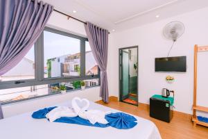 1 dormitorio con cama y ventana grande en Vinh Khang Homestay en Hoi An