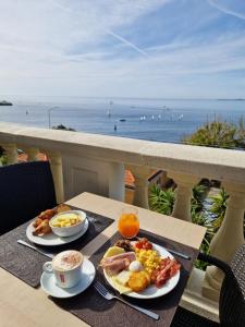 - une table avec 2 assiettes de petit-déjeuner sur un balcon dans l'établissement Hotel Le Saint Paul, à Nice