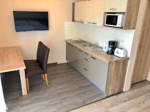 a small kitchen with a table and a microwave at Unio Vendégház 1 in Siófok