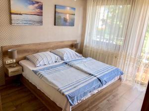 A bed or beds in a room at Unio Vendégház 1
