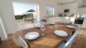 a wooden table with plates and wine glasses on it in a kitchen at Rhossili Reach in Rhossili