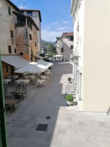 an empty street with tables and chairs and umbrellas at Apartment in Lovran in Lovran