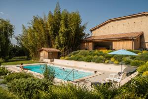 a swimming pool in front of a building at SALVEO Suites in Loubens