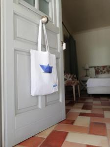 a white tote bag hanging on a door at Gaia accommodation Hydras in Hydra
