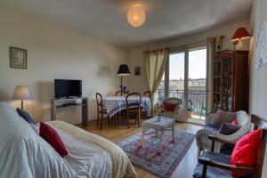 - une chambre avec un lit et un salon dans l'établissement Appartement de charme au cœur de la Corrèze, à Brive-la-Gaillarde