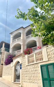 a building with a balcony with flowers on it at Villa Mira in Bol