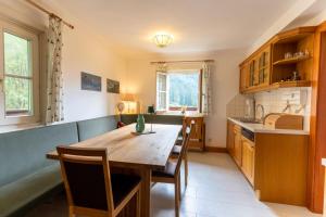a kitchen with a wooden table and chairs at Malerwinkel, Forsthaus in Bad Gastein