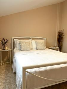 Aktaia Villa في إيريسوس: غرفة نوم بسرير أبيض مع شراشف ووسائد بيضاء
