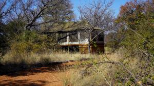 an old house sitting in the middle of a field at Iphofolo Lodge & Tented Camp in Vivo