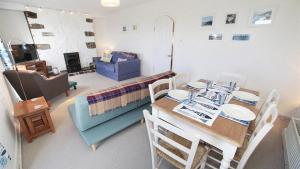 a living room with a table and a dining room at Daisy Cottage in The Mumbles