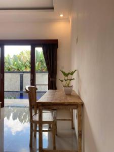 a wooden table and chair with a potted plant on it at The Lucky Canggu in Canggu