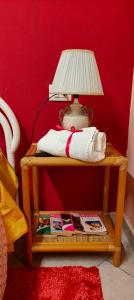 a lamp on a table with a red wall at La casetta di nonna Sesa in Viterbo
