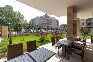 einen Balkon mit einem Tisch und Stühlen sowie einem Park in der Unterkunft Emilia Romana Park in Sonnenstrand